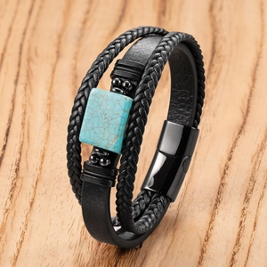 Detail of multi-layer black braided leather bracelet with turquoise stone and magnetic clasp