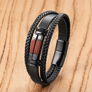 Detail of multi-layer black braided leather bracelet with red stone and magnetic clasp