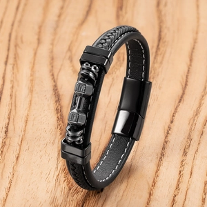 Detail of men's black leather bracelet with dumbbell charm and motivational engraving