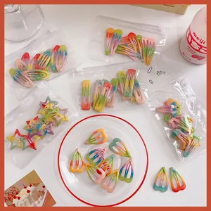 Close-up of colorful gradient glitter hair clips in various shapes with a storage bag