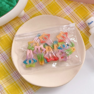 Detailed view of rainbow glitter star hair clips in a transparent slide lock pouch
