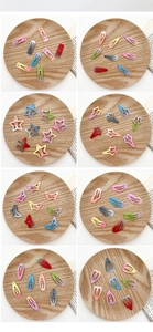 Détail de barrettes à cheveux en métal dégradé en formes d'étoiles et de cœurs sur plateau