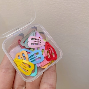 Detailed view of colorful heart-shaped mini hair clips stored in a clear plastic box