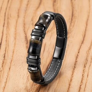 Dettaglio di un bracciale in pelle da uomo con perle occhio di tigre e chiusura magnetica