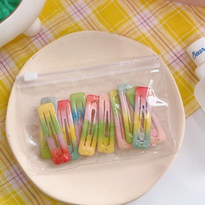 Close-up of glitter gradient star hair clips set in transparent zipper bag on a tray