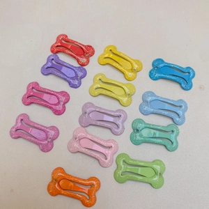 Dettaglio macro di 12 fermagli per capelli a forma di osso in colori caramella glitter