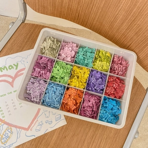 Dettaglio di 15 fermagli per capelli a forma di osso in vari colori in una scatola ordinata