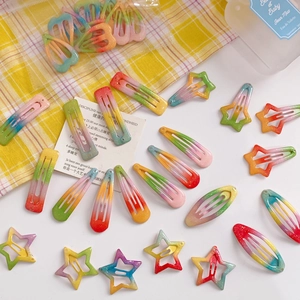 Flat lay of rainbow gradient glitter star and heart hair clips on white background