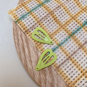 Detail of light green heart-shaped mini BB clips with matte lacquer finish
