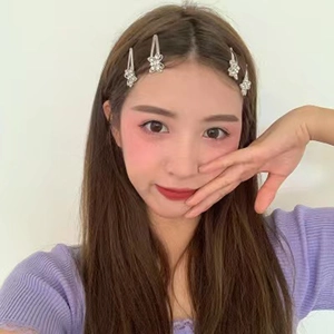 Close-up of four silver butterfly hair clips with sparkling rhinestones on model's hair