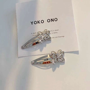 Close-up of two sparkling butterfly hair clips with white rhinestones on display card