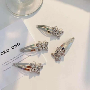 Detailed view of four silver butterfly hair clips with sparkling rhinestones in a set