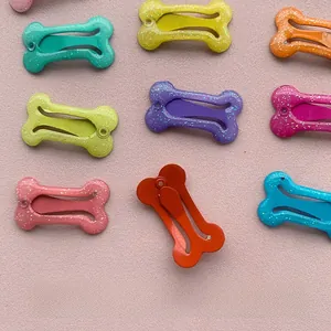 Dettaglio di fermagli a forma di osso antiruggine con finitura laccata e glitterata