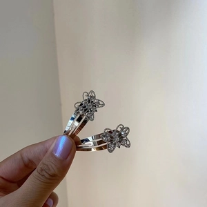 Close-up of sparkling silver butterfly hair clips with crystal rhinestones on a hand