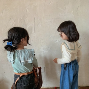 Détail de pulls en tricot pour bébé fille avec grands cols à volants en menthe et crème