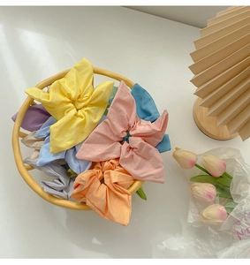 Close-up of colorful pastel scrunchies set in a yellow tray with a soft home decor background