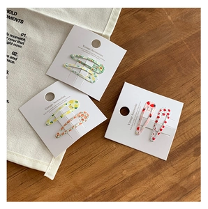 Gros plan de 6 barrettes BB colorées avec motifs de fruits comme l'avocat et la fraise