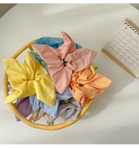 Detail of candy-colored star-shaped fabric scrunchies in a woven basket
