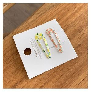 Détail de barrettes vintage à motif de fruits avec des textures de citron et orange
