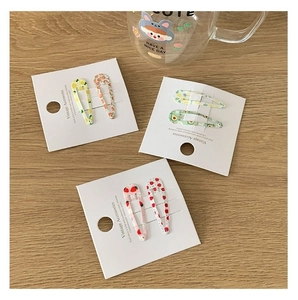 Lot de barrettes à cheveux motifs fruits d'été citron et fraise sur table en bois