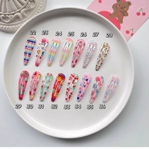 Detailed view of 15 colorful floral and fruit pattern BB hair clips for kids