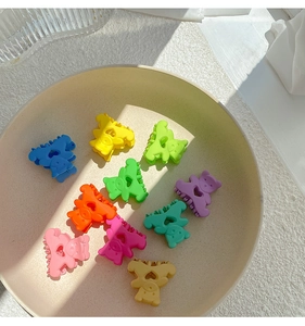 Détail de mini pinces à cheveux ours mates aux couleurs acidulées avec motif de cœur évidé