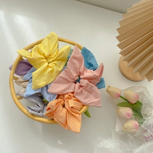 Set of pastel candy colored scrunchies with star pleats in a yellow basket