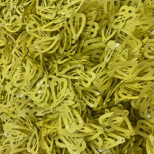 Close-up of bulk yellow heart-shaped mini hair clips with a glossy painted metal finish
