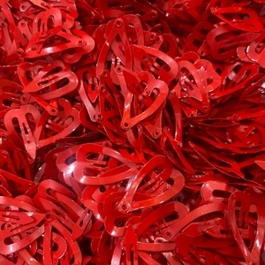 Close-up of bulk mini red heart-shaped metal hair clips with a glossy painted finish