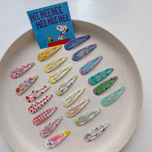 Colorful floral and fruit patterned drip glue BB hair clips for kids in a ceramic dish