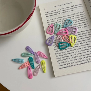 Set di fermagli per capelli colorati a goccia sparsi su una pagina di libro