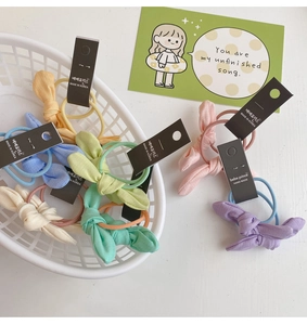 Chouchous en tissu colorés avec oreilles de lapin dans un panier blanc aux tons pastel