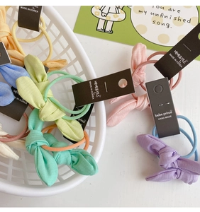 Détail de chouchous en tissu avec nœuds aux couleurs macaron et élastique haute densité