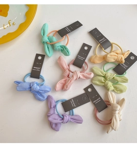 Détail d'un lot d'élastiques à cheveux avec nœuds colorés pastel et bandes élastiques