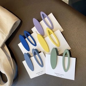 Close-up of matte oval hair clips in Morandi colors on a jewelry display card