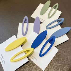 Set of colorful matte oval hair clips in green purple and blue on display card
