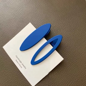 Set of two matte blue oval hair clips including solid and hollow frames on card