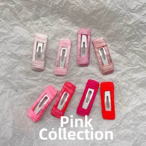Detailed close-up of 8 pink and red ribbon wrapped BB hair clips on white paper