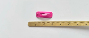 Primo piano del fermaglio per capelli in metallo opaco rosa da 2,8 cm con righello