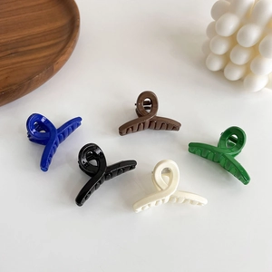 Detailed view of mini cross hair clips in glossy blue, coffee, black, cream, and green colors