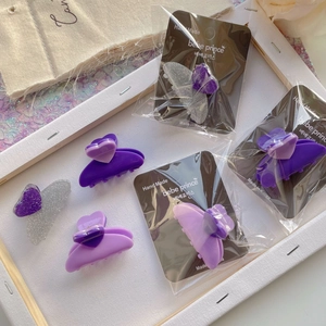 Detail shot of purple and silver glitter acetate hair claws with heart shaped resin decor