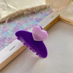 Close-up of purple heart-shaped acetate hair claw clip with pink heart accent