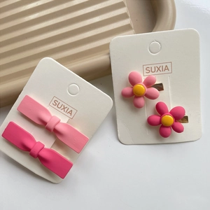 Sweet pink bow and flower hair clips set for girls on display card with soft lighting