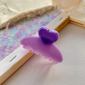 Detail of a purple heart hair claw clip with matte finish and glossy resin ornament