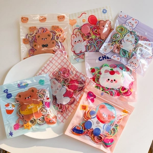 Detail of colorful elastic hair bands in cartoon bear frosted zipper packaging pouches