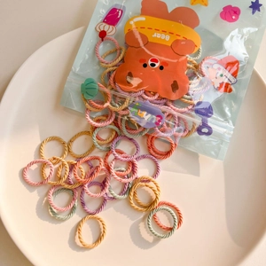 Detailed macro view of pastel macaron hair ties with twisted texture and cute bear bag