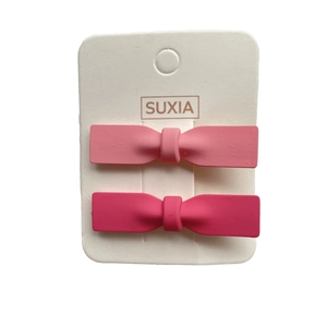 Pink and magenta matte bow hair clips set on a display card for girls and women