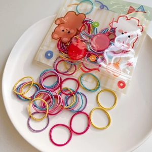 Close-up of assorted candy-colored elastic hair ties in a cute cartoon animal packaging bag
