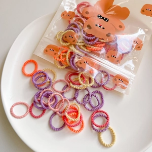 Detail of colorful macaron elastic hair bands in a cute brown bear pattern zip bag