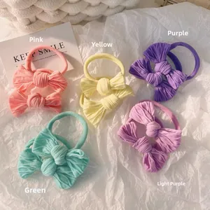 Detailed close-up of colorful corduroy bow hair ties in five pastel macaron shades
